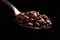 A breathtaking photo of coffee beans in a spoon on a black background. Banner with place for text for advertising or