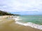 A breathtaking shot of the deep green ocean water and the beach and the waves crashing against the rocks