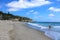 A breathtaking shot of the deep green ocean water and the beach and the waves crashing against the rocks