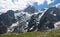 Breathtaking shot of the La Meije glacier towering above a large empty meadow.