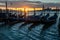 Breathtaking sunrise over the lagoon of Venice with gondolas moored at quai