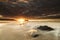 Breathtaking susnet from the dark sky over the fizzy water in Holywell Bay, Cornwall, UK