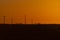 Breathtaking view of an orange sunset with silhouette of transmission towers and a car