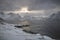Breathtaking winter landscape with the icy Norwegian sea at sunset. Glacial mountains around the village of Husoy, in northern