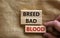 Breed bad blood symbol. Businessman holds wooden block with words `Breed bad blood`. Beautiful canvas background, copy space.