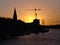 Bremen, Germany - River Weser with St. Martini church and construction site with large crane silhouetted against the sunrise