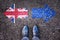 Brexit, flags of the United Kingdom and the European Union on asphalt road