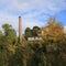 Brich chimney, old factory Schoenau surrounded by colorful trees