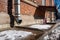 Brick building with rain pipes on the facade and entrance to the basement