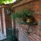 a brick-built fence, decorated with a discreet iron shelf and a caldeabra