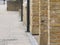 Brick built pillars and black drain pipes beside pavement in street