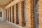 Brick columned walkway with tall windows and sidewalk