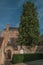 Brick facade of house, tree and blue sky in a peaceful courtyard in Bruges.