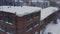 Brick Facade of the industrial building against the background of the winter landscape. Aerial view