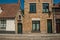 Brick facade of old houses and doors with blue sky, in an empty street of Bruges.