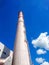 Brick factory pipe on a background of blue sky with white clouds. Bottom view. The concept of cleaner production