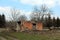 Brick family house ruins surrounded with dried trees and small vegetation