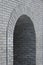 Brick gray wall with a semicircular arch entrance