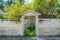 Brick grey fence with gateway leading to house in the village at tropical island