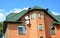 Brick house with attic and green metal roof. Gable and Valley