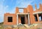 Brick house building construction. Brick building unfinished house construction with entrance door, balcony