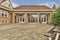 a brick house with glass doors and a gravel patio