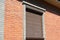 Brick house window with rolling shutter for house protection.