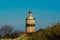 A brick lighthouse with a bright blue sky in the background. Picture of Falsterbo Lighthouse from 1796 in Scania