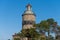 A brick lighthouse with a bright blue sky in the background. Picture of Falsterbo Lighthouse from 1796 in Scania