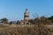 A brick lighthouse with a bright blue sky in the background. Picture of Falsterbo Lighthouse from 1796 in Scania