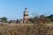 A brick lighthouse with a bright blue sky in the background. Picture of Falsterbo Lighthouse from 1796 in Scania