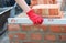 Brick masonry: A bricklayer is checking the evenness of a brick wall, brick foundation using a spirit level