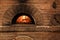 Brick oven with burning firewood and pizzas