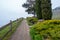 Brick pathway with wooden rail at viewpoint in rural area of Switzerland on cloudy sky background