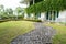 A brick paved road stretches into the garden