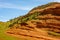 Brick red sandstone geological Chugwater formations contrast with blue sky found in Wyoming off Chief Joseph Byway.