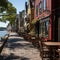 Brick road alongside the water with lively tavern scenes