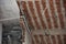 Brick room walls and ceiling view of a being demolished building with electricity, water and ventilation installations