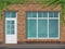 Brick store front with large window and ivy