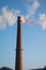 Brick tall pipe with thick smoke closeup. Environmental pollution, ecology. Vertical orientation