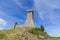 Brick tower Rocca of Radocofani on top the basalt hill with sky background on a summer day, Tuscany, Italy