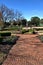 Brick walkway leading into a scenic landscaped yard