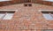 Brick Wall with brown Windows, side view of the house