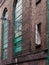 Brick wall building exterior with high arched window.