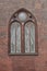 Brick wall of the Church with beautiful arched stained glass window. Beautiful architecture. Details.