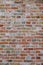Brick wall, with colorful colored bricks, red, green, gray, brown in summer in Bruges, Belgium, red wall texture, as background.