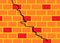 A brick wall construction with orange and random red bricks cemented with a deep crack stress line across