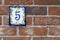 Brick wall with house number plate