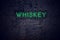 Brick wall at night with neon sign whiskey