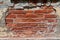 The brick wall of an old building with fallen plaster